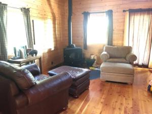a living room with a couch and a chair and a stove at Beautiful Mountain Cabin near Tetons Yellowstone in Dubois