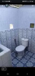a bathroom with a toilet and a sink at Red Beach Homestay in Pasanggaran