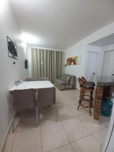 uma sala de estar com uma mesa e cadeiras e um sofá em Apartamento Porto das Dunas em Aquiraz