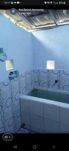 ein Badezimmer mit einer Badewanne und einem Waschbecken in der Unterkunft Red Beach Homestay in Pasanggaran