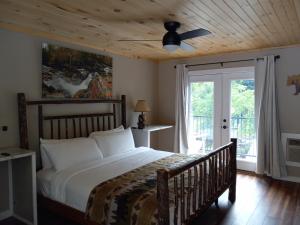 a bedroom with a bed and a ceiling fan at Carter Lodge - On The River in Chimney Rock