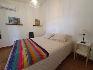 Un dormitorio con una cama con una manta colorida encima. en LO DE MECHI, en Salta