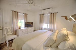 a white bedroom with a bed and a television at Gulfside Resort. Unit 3 in St. Pete Beach +22 photos
