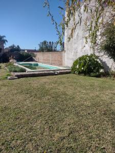 een zwembad in een tuin met een grasveld bij La Casa de Ana in San Antonio de Areco