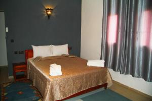 a bedroom with a bed with two towels on it at Riad Ouinz in Aït Benhaddou