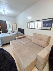 a living room with a couch and a bed at Belo apt próximo ao Consulado in Porto Alegre
