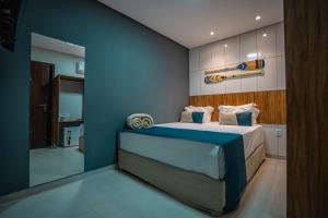a bedroom with a bed with a blue wall at Pousada Antonella in Maragogi