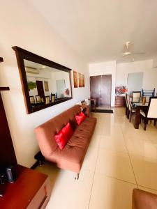a living room with a brown couch and a mirror at SkyLounge Apartment 2 Colombo in Colombo
