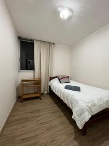 um pequeno quarto com uma cama e uma televisão em Apartamento Amoblado 132 Ovalle em Ovalle