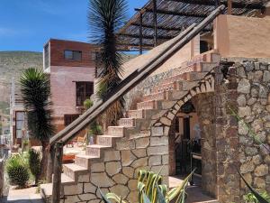 un edificio de piedra con una escalera delante en HOTEL RINCÓN MAGICO REAL DE CATORCE, en Real de Catorce