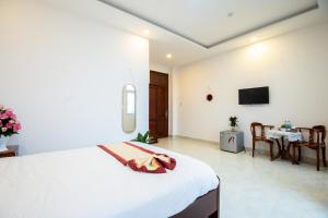 - une chambre avec un grand lit et une salle à manger dans l'établissement Tuấn An Hotel, à Đà Lạt