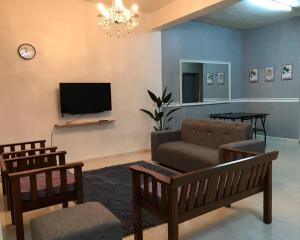 a living room with a couch and a tv at Julia Homestay Taman Tasik Utama MiTC in Melaka