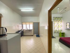a room with a kitchen and a living room at Julia Homestay Taman Tasik Utama MiTC in Melaka