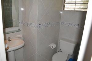 a bathroom with a white toilet and a sink at Casa frente al mar - Internet - SmartTV - Netflix - DirectTV in Tonsupa