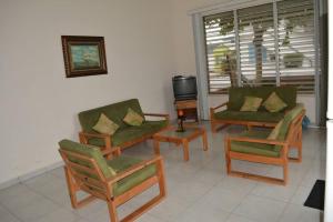 salon z kanapami i krzesłami oraz telewizorem w obiekcie Casa frente al mar - Internet - SmartTV - Netflix - DirectTV w mieście Tonsupa