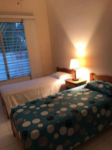 sypialnia z 2 łóżkami, lampką i oknem w obiekcie Casa frente al mar - Internet - SmartTV - Netflix - DirectTV w mieście Tonsupa