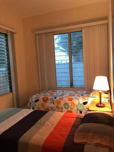 a bedroom with two beds and a lamp and windows at Casa frente al mar - Internet - SmartTV - Netflix - DirectTV in Tonsupa