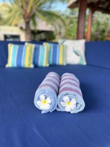 two towels with white flowers on a blue table at Seaside Villa Kecil in Sekotong