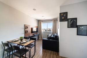 a living room and dining room with a table and a couch at 1604 - Apto com piscina Prox Bras e Centro in Sao Paulo