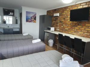 um quarto com duas camas e uma parede de tijolos em Morwell Parkside Motel em Morwell