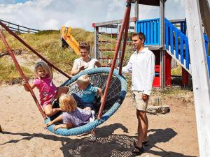 a group of people sitting in a swing at 8 person holiday home in Ringkøbing-By Traum in Ringkøbing