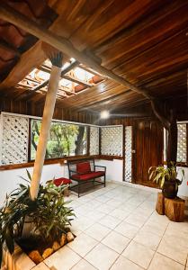 a screened in porch with a bench and windows at Hacienda Sarah in Nosara
