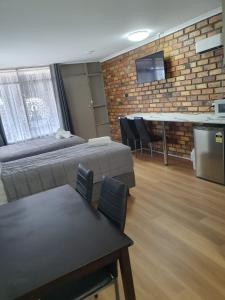 um quarto com uma cama, uma mesa e cadeiras em Morwell Parkside Motel em Morwell