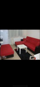 a living room with a red couch and a coffee table at Uraz Apart in Bursa