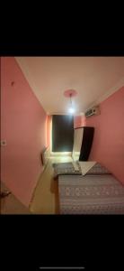 ein kleines Zimmer mit einer rosa Wand und einer Lampe in der Unterkunft Uraz Apart in Bursa