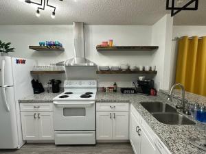 a kitchen with a white stove and a sink at Coral Sky in Pensacola