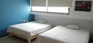 2 camas en una habitación con una pared azul en Palma Dorada Country, en Villahermosa