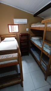 a room with three bunk beds and a window at Hostel Alto Astral - Fonte in Morro de São Paulo