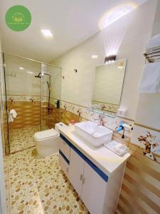 y baño con aseo, lavabo y ducha. en Mai An Homestay, en Thôn Trường Giang