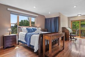 a bedroom with a bed and a desk and a window at Coppertop- Firepit-Skyline Views in Rapid City