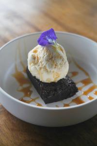 a white bowl with a dessert with a flower on it at Bubble Siargao in General Luna