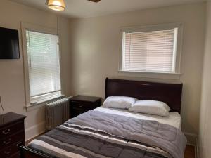 a bedroom with a bed with two pillows and two windows at A comfortable home for you in Trenton