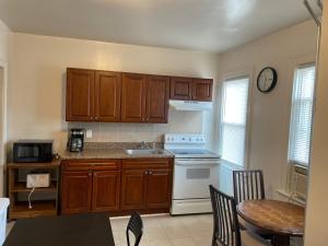 cocina con armarios de madera, fregadero y mesa en A comfortable home for you, en Trenton