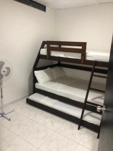 two bunk beds in a room with a fan at Casa con calor de hogar con aire acondicionado in Neiva