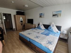 een slaapkamer met een bed met blauwe lakens en kussens bij Pension Haus Erika in Cuxhaven