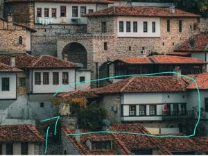 eine Gruppe von Gebäuden mit roten Ziegeldächern in der Unterkunft Hostel Mangalem in Berat