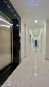 a hallway with white walls and a black and white tile floor at Bamboo Hotel Vung Tau in Vung Tau