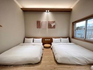 台南的住宿－河趣泊旅 River Chill Inn，配有白色床单的客房内的两张床