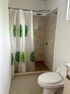 a bathroom with a toilet and a shower curtain at Casa Martin Cahuita Charming Spanish Home in Cahuita