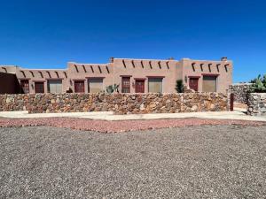 a large house with a stone wall in front of it at Departamento Casa Blanca Paquimé in Nuevo Casas Grandes