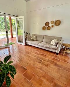 a living room with a couch and a wooden floor at Casa Martin Cahuita Charming Spanish Home in Cahuita
