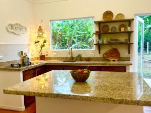 a kitchen with a counter with a bowl of fruit on it at Casa Martin Cahuita Charming Spanish Home in Cahuita