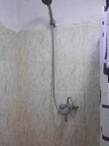 a shower in a bathroom with a hose on the wall at Kathy B Guesthouse in Luganville
