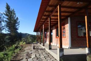ein Gebäude mit einem Holzdach und einem Steinsteg in der Unterkunft Puyu Pacha Adventure in Sigchos