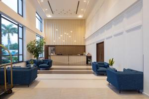 a lobby with blue chairs and a counter at Le Palmier Ho Tram Resort - Beachfront with Private Beach in Ho Tram +259 photos