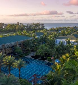 an aerial view of a resort with a pool and the ocean at Le Palmier Ho Tram Resort - Beachfront with Private Beach in Ho Tram